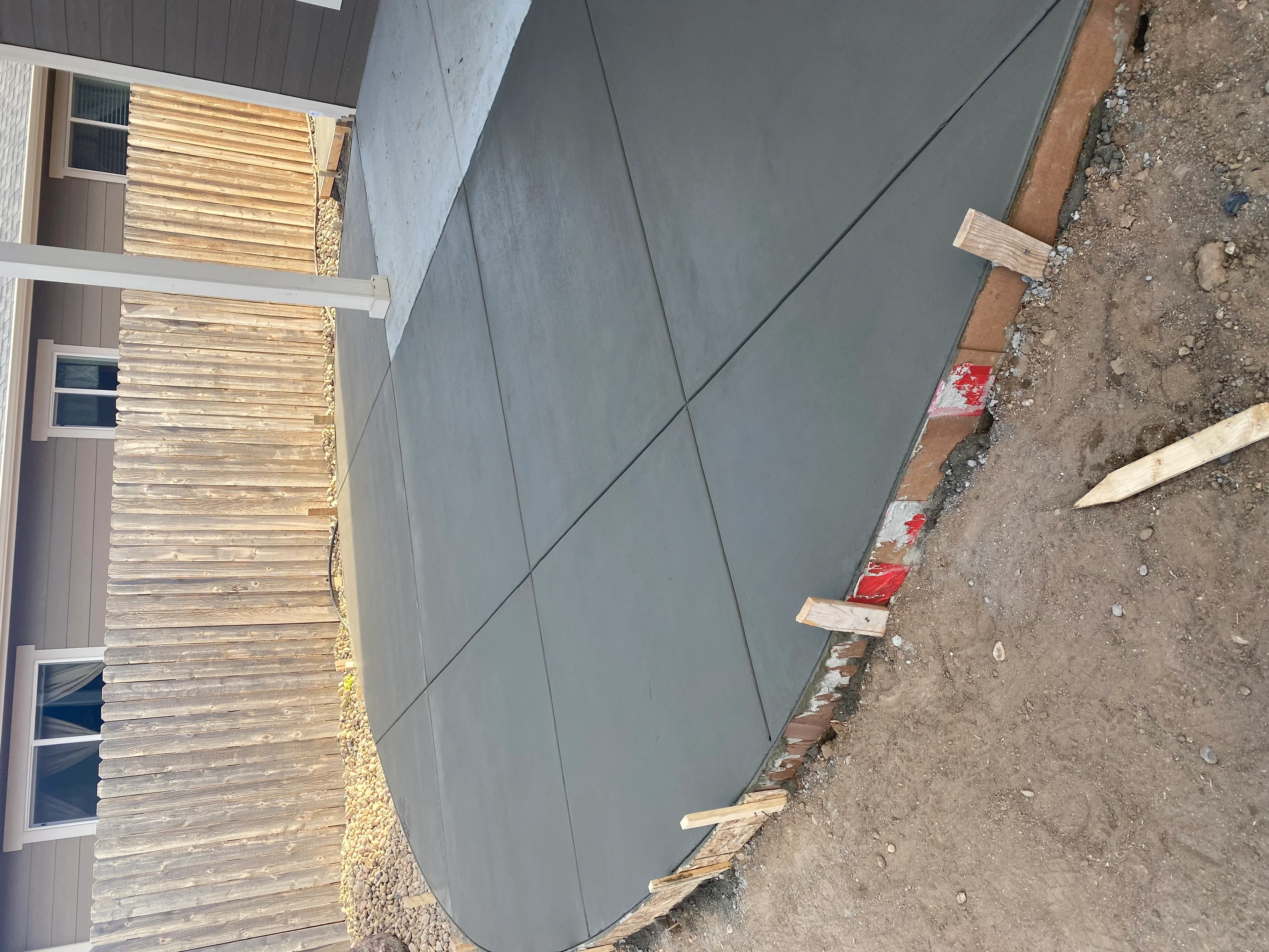 Freshly poured concrete driveway with control joints and wooden edge forms